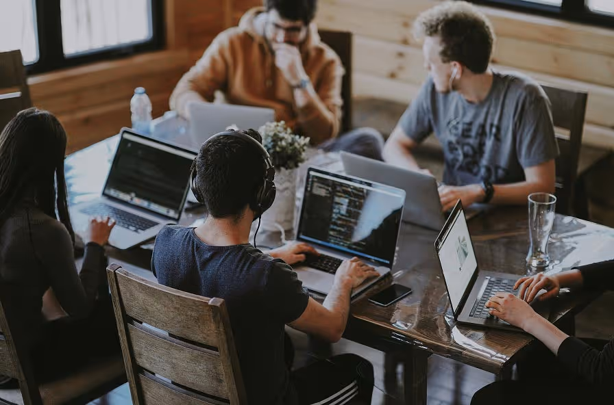 A professional services team working together at a laptop
